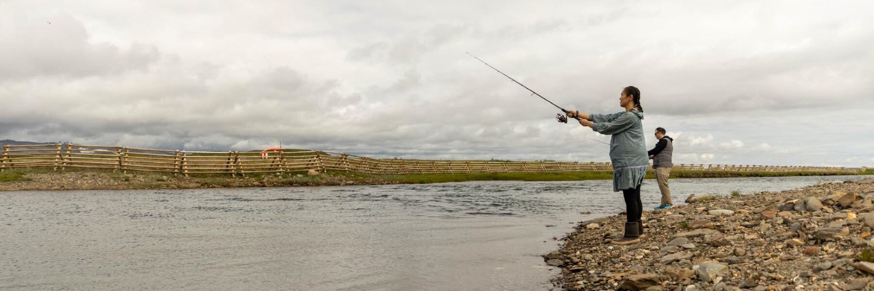 Female fishing for salmon in nome during summer subsistence season.